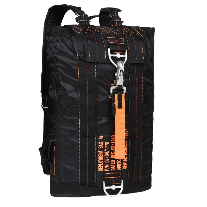 Load image into Gallery viewer, Black backpack with orange accents and a deployment bag tag on a white background
