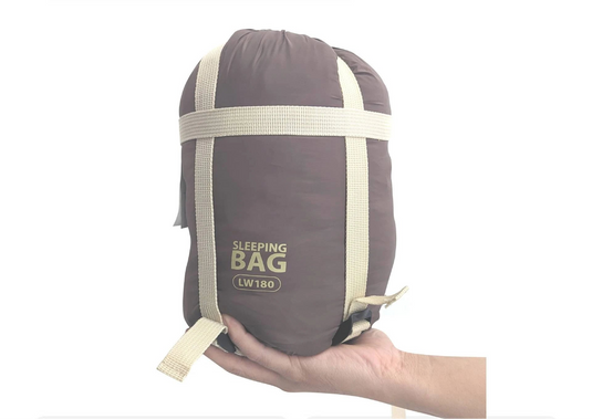 Sleeping bag labeled LW180 held by a hand with text about its portability.