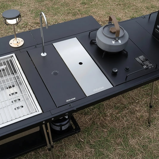 Tabletop camping stove with pot and accessories on a grassy background, featuring text about securing the cover and maximizing camp space.