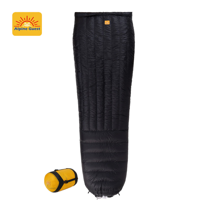 Load image into Gallery viewer, Black sleeping bag with rolled-up version on a white background, featuring Alpine Guest logo.
