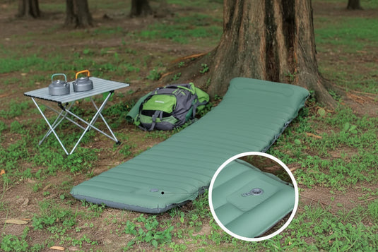A green inflatable camping mattress in a forest setting.