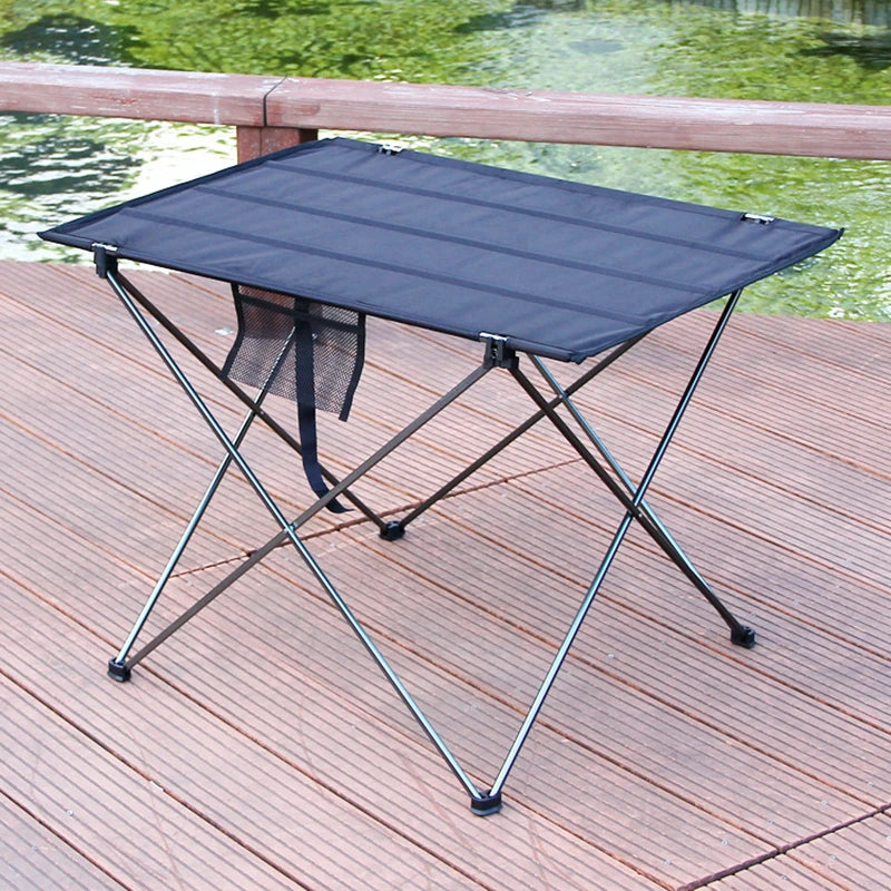 Load image into Gallery viewer, Portable folding table on a wooden deck with a body of water in the background
