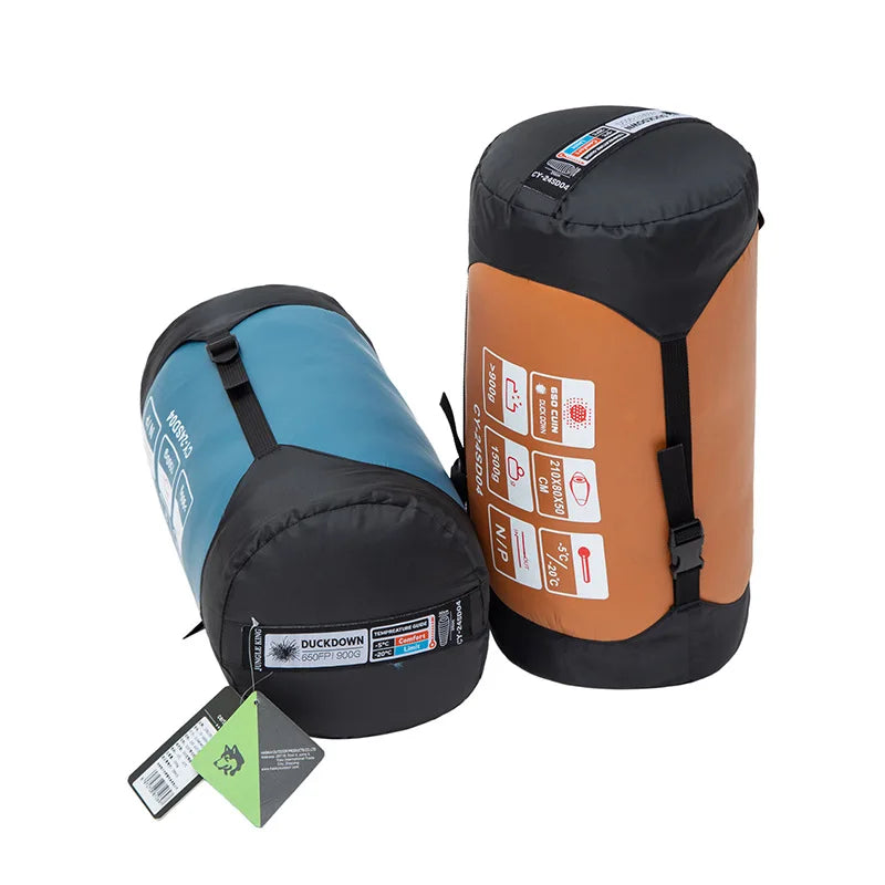 Load image into Gallery viewer, Two sleeping bags, one blue and one orange with black straps, on a white background.
