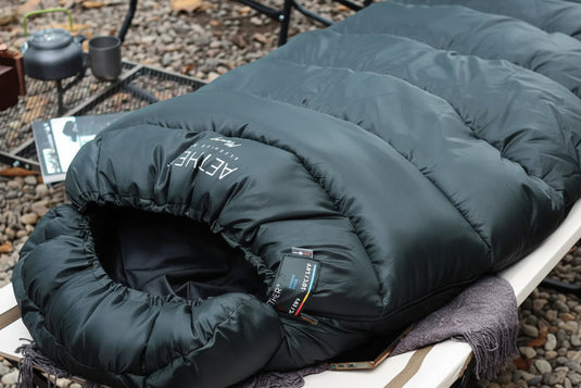 A dark green sleeping bag outdoors
