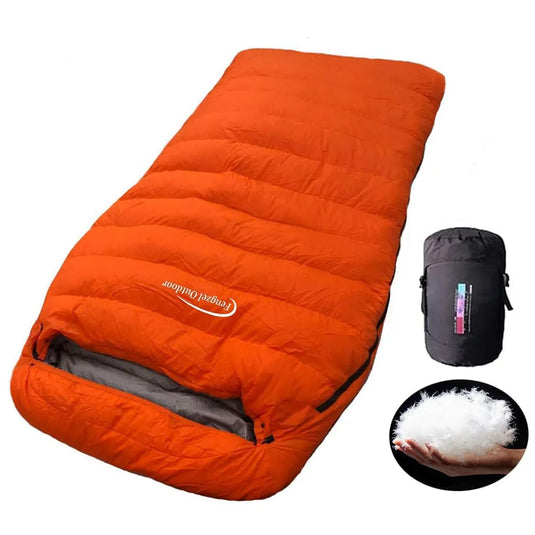 Orange sleeping bag with compression sack and fill material on a white background