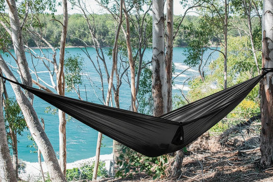 Black hammock with mosquito netting and features highlighted on a white background