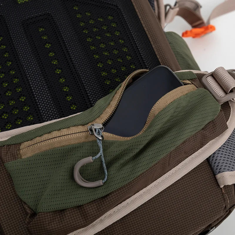 Load image into Gallery viewer, Close-up of a green and brown backpack with a phone in a pocket.
