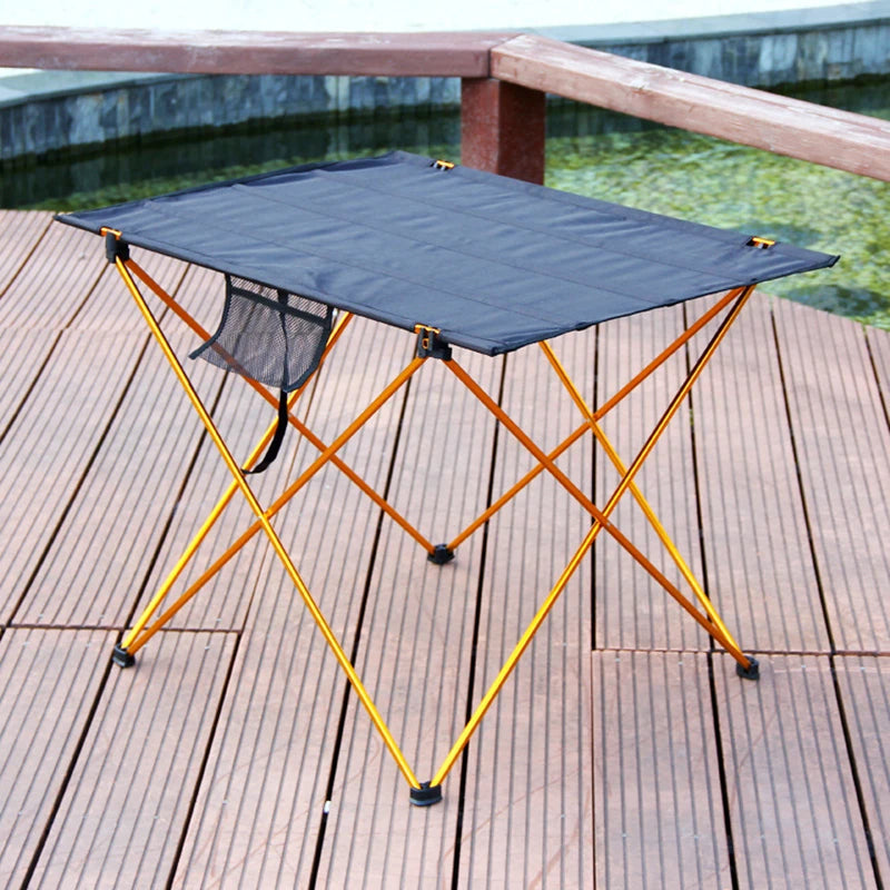 Load image into Gallery viewer, Portable folding table with blue top and yellow frame on a wooden deck by a pool.
