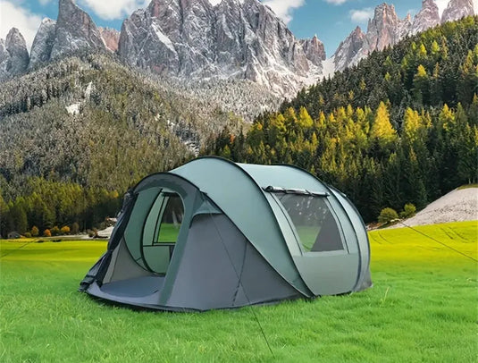 Camping tent in a scenic outdoor setting with mountains and trees.