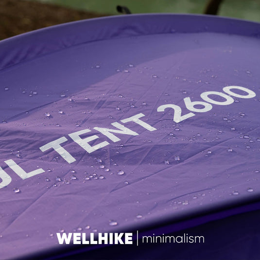Purple tent with 'WELLHIKE minimalism' branding and water droplets on the fabric.