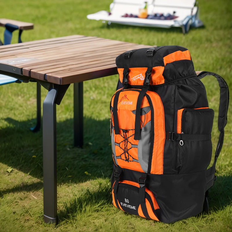 Load image into Gallery viewer, Orange and black backpack on grass next to a wooden table
