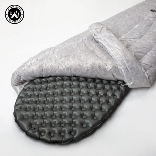 Gray sleeping bag and black inflatable mattress on a white background with a brand logo.