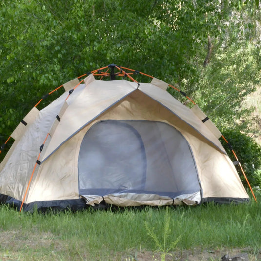 Beige camping tent with a screen door on grass with trees in the background