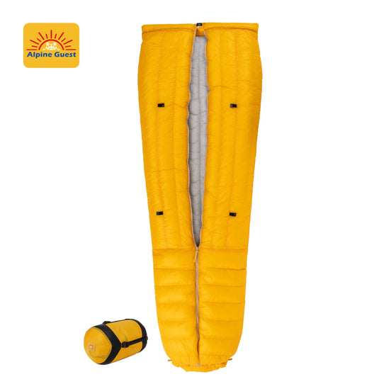 Yellow sleeping bag with rolled-up version on a white background, featuring Alpine Guest logo.