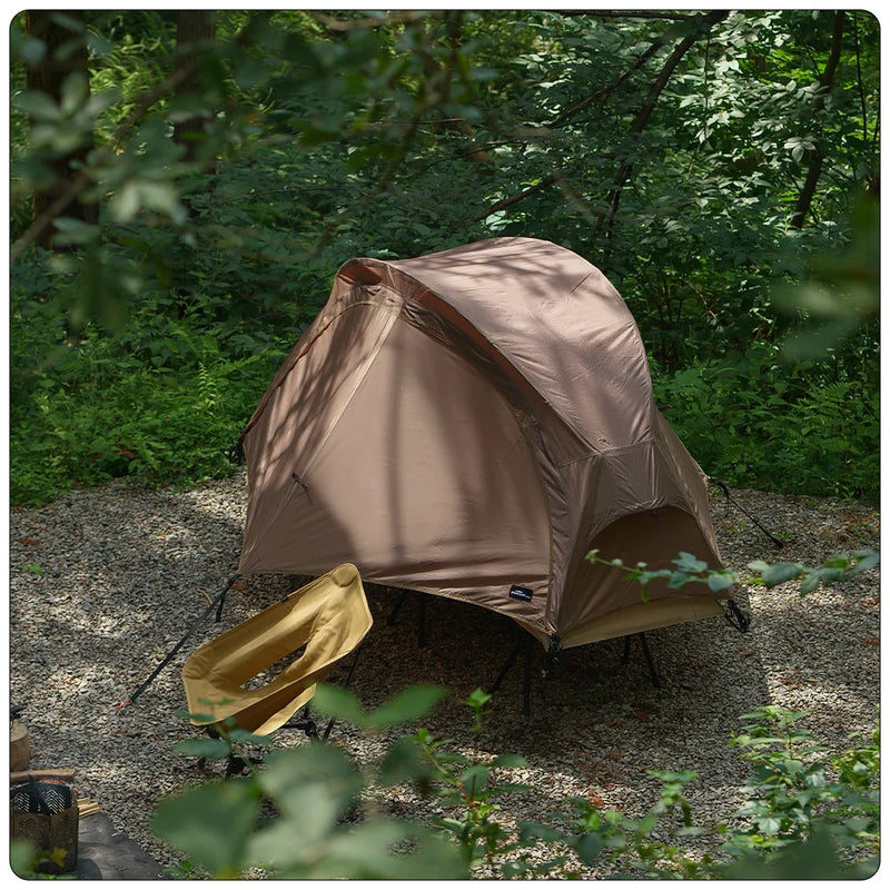Load image into Gallery viewer, Brown tent set up in a forested area
