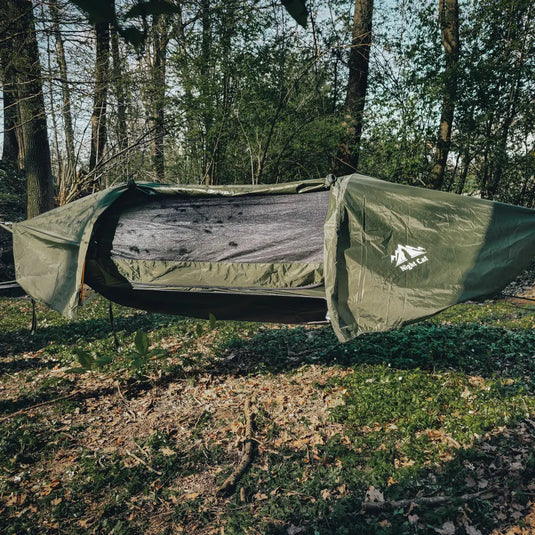 Green tent with Adidas logo set up in a forest